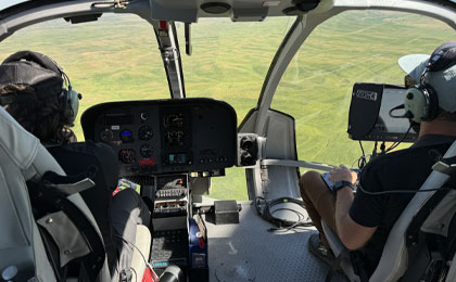 Helicopter cabin with GSS deck camera operator filming  scenic view of the landscape by Maverick Helicopters.