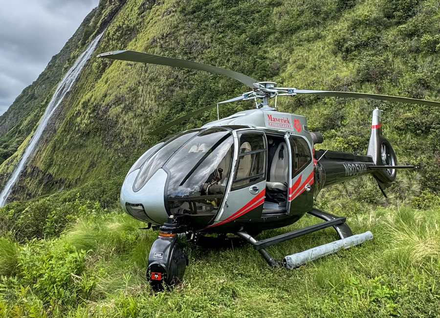 Maverick Airbus EC130 helicopter on the ground in Hawaii, equipped with an externally mounted camera system for aerial film production.