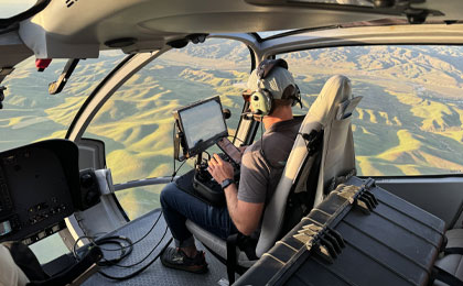 Helicopter cabin filming during sunset with scenic view of the landscape by Maverick Helicopters.