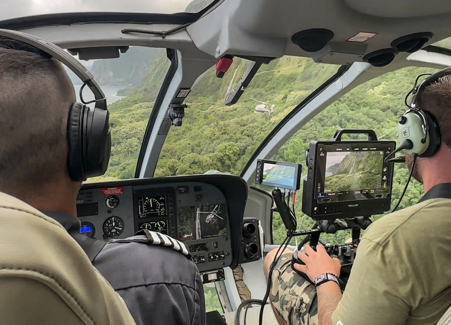 Camera operator inside a Maverick helicopter using the SHOTOVER control console during an aerial film production in Hawaii.