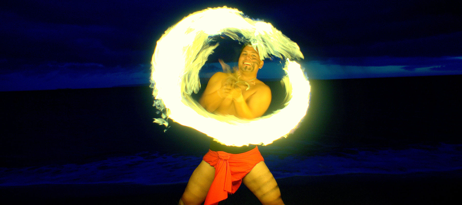 Fire poi spinner in motion during this luau experience