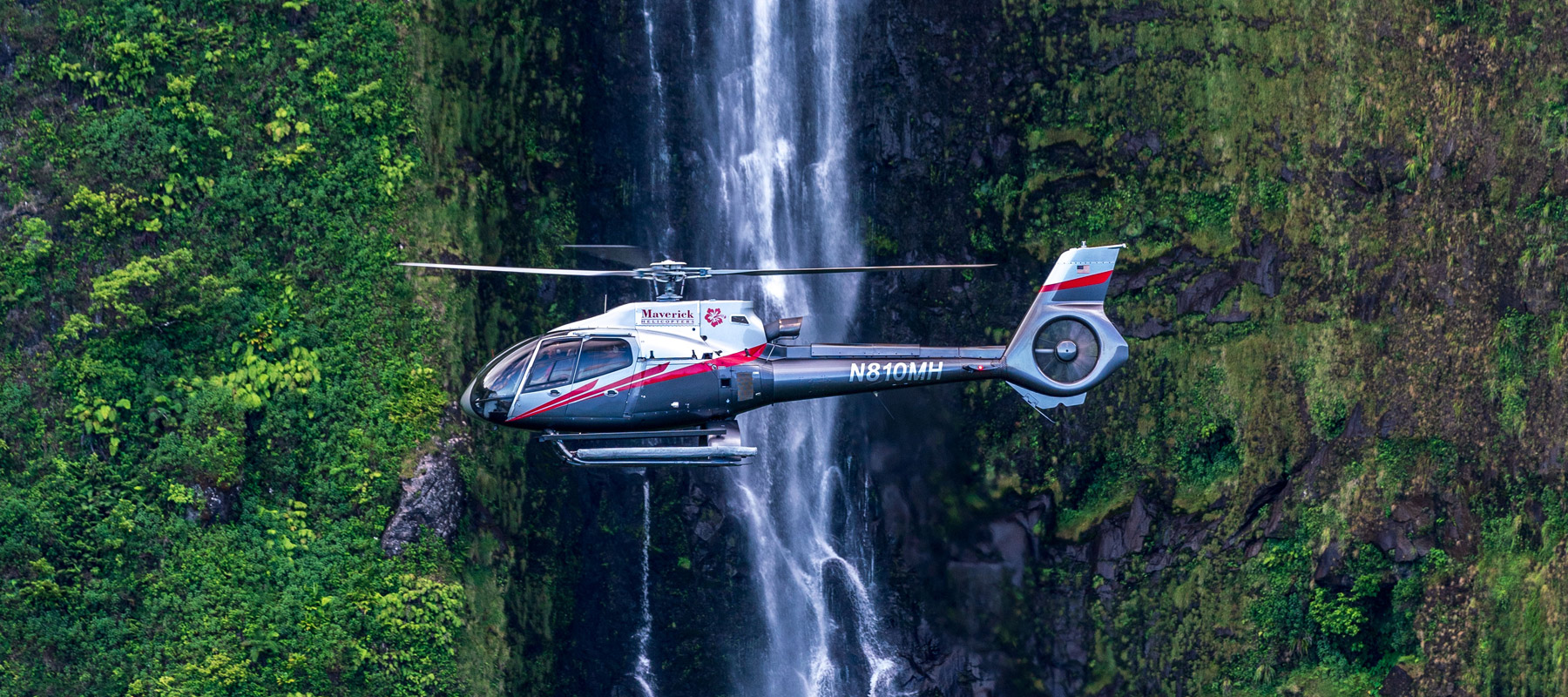 Approaching a waterfall in the lush mountains of Molokai on this island experience with Maverick Helicopters